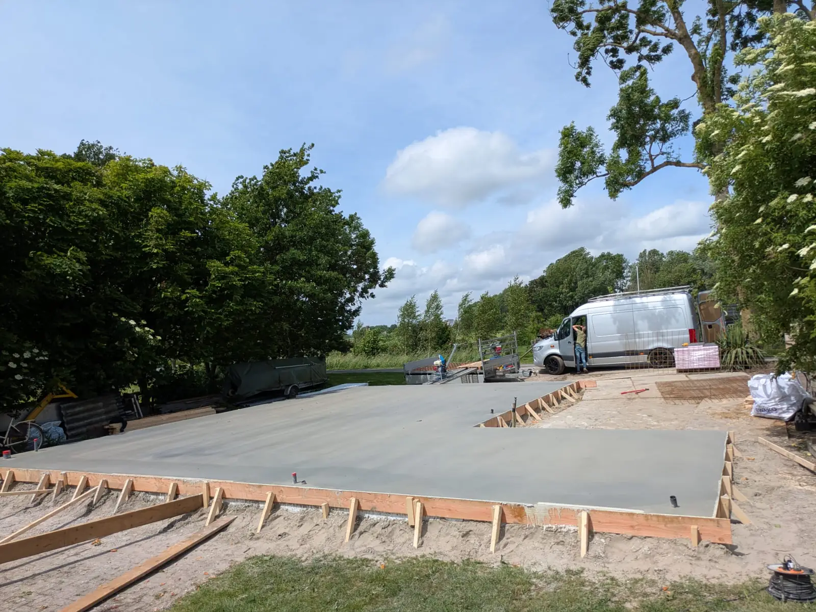 Grote afgewerkte betonvloer op een erf met bekisting eromheen