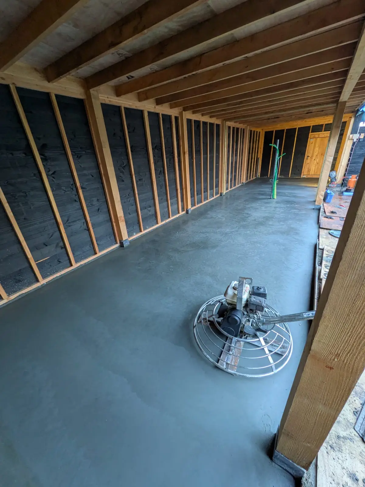 Vlindermachine op een pas gevlinderde betonvloer in een houten bijgebouw