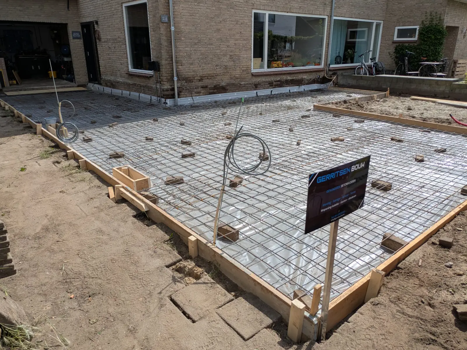 Wapening, folie en isolatie voor een betonnen terrasvloer bij een woning